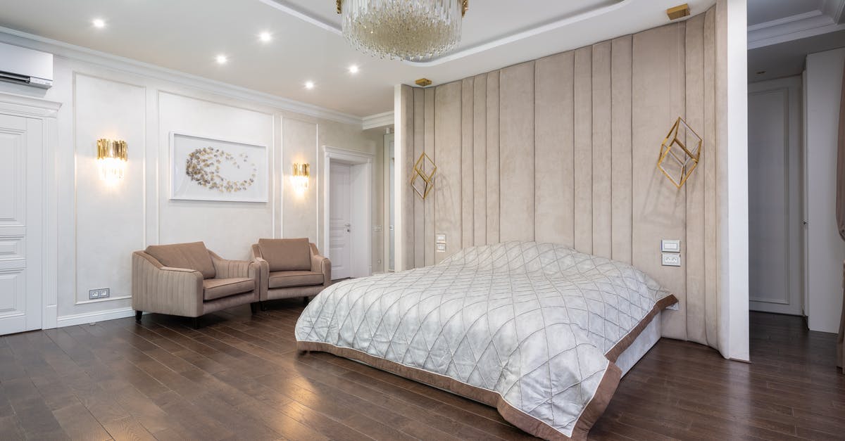 Why don't American hotels have ceiling lights? - Bedroom with armchairs next to bed Why don't American hotels have ceiling lights? - Bedroom with armchairs next to bed