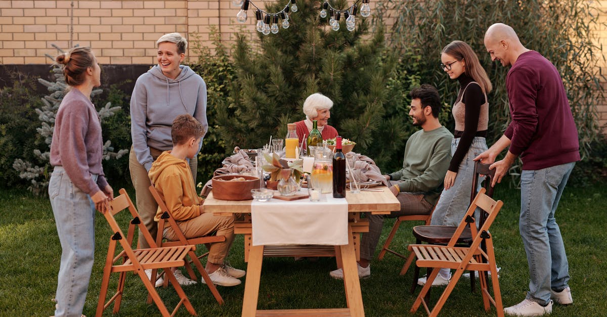 Why don't hotels in NZ have lamps? - Happy family members talking and sitting down to eat tasty food at big wooden table in backyard in daytime Why don't hotels in NZ have lamps? - Happy family members talking and sitting down to eat tasty food at big wooden table in backyard in daytime