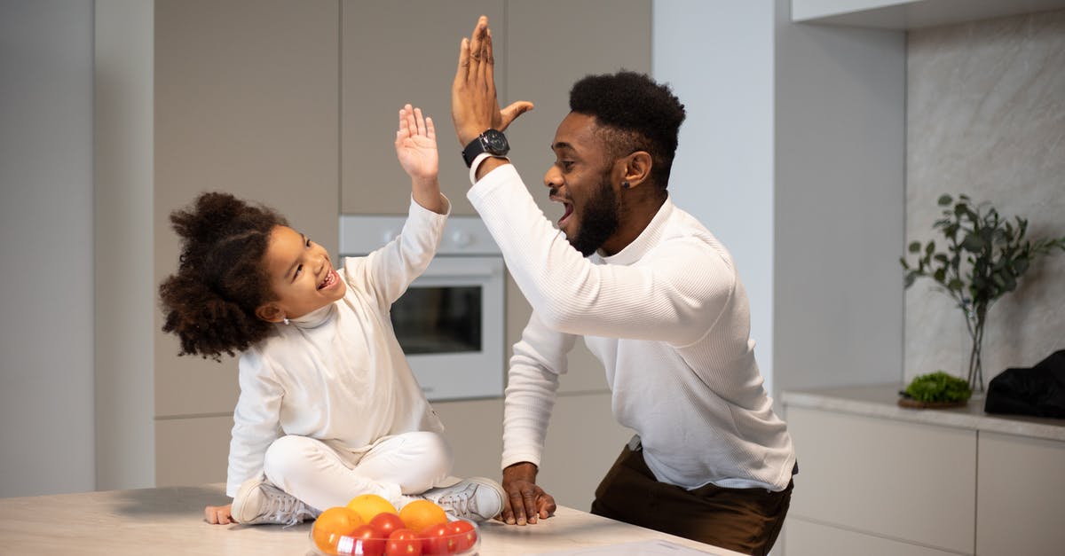 Why don't they give you a sweet on take-off anymore? - Joyful black father giving high five to adorable daughter Why don't they give you a sweet on take-off anymore? - Joyful black father giving high five to adorable daughter