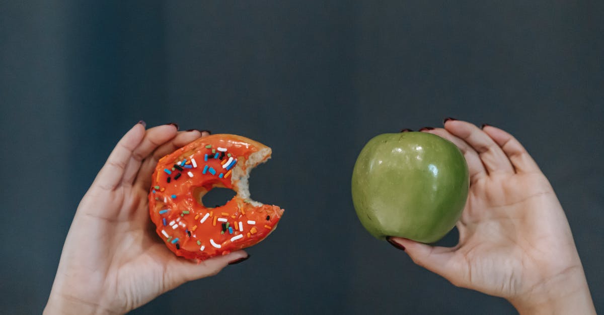 Why don't we ask air travelers to choose their meal in advance? [closed] - Crop unrecognizable young female demonstrating bitten high calorie doughnut and healthy green apple against gray background