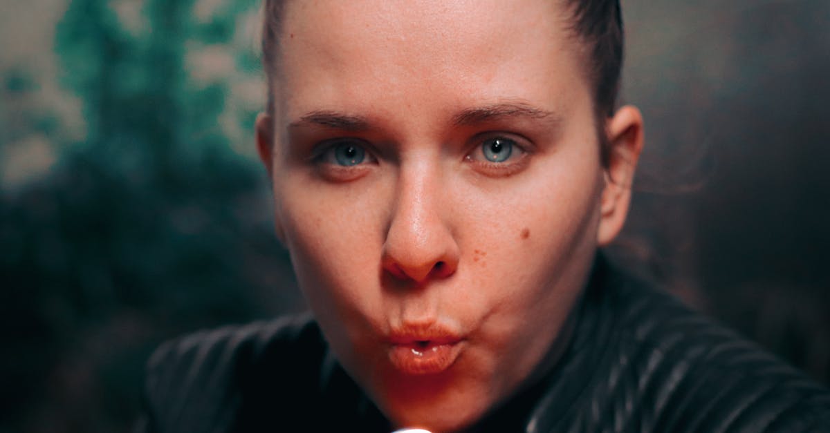 Why is blowing your nose rude in Japan? - Close-Up Photo of Woman Blowing a Lighter