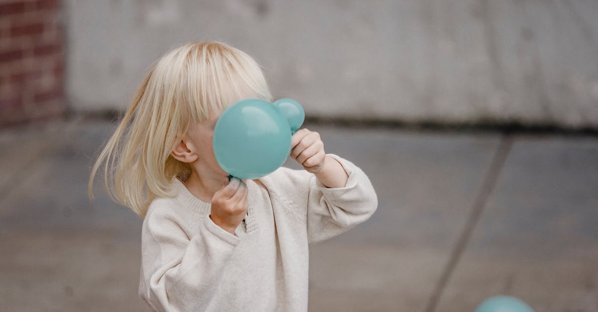 Why is Google Search giving me different values for "Time zone [city]" versus "Time in [city]"? - Anonymous blond kid in casual apparel playing with blue balloons on city street in daylight