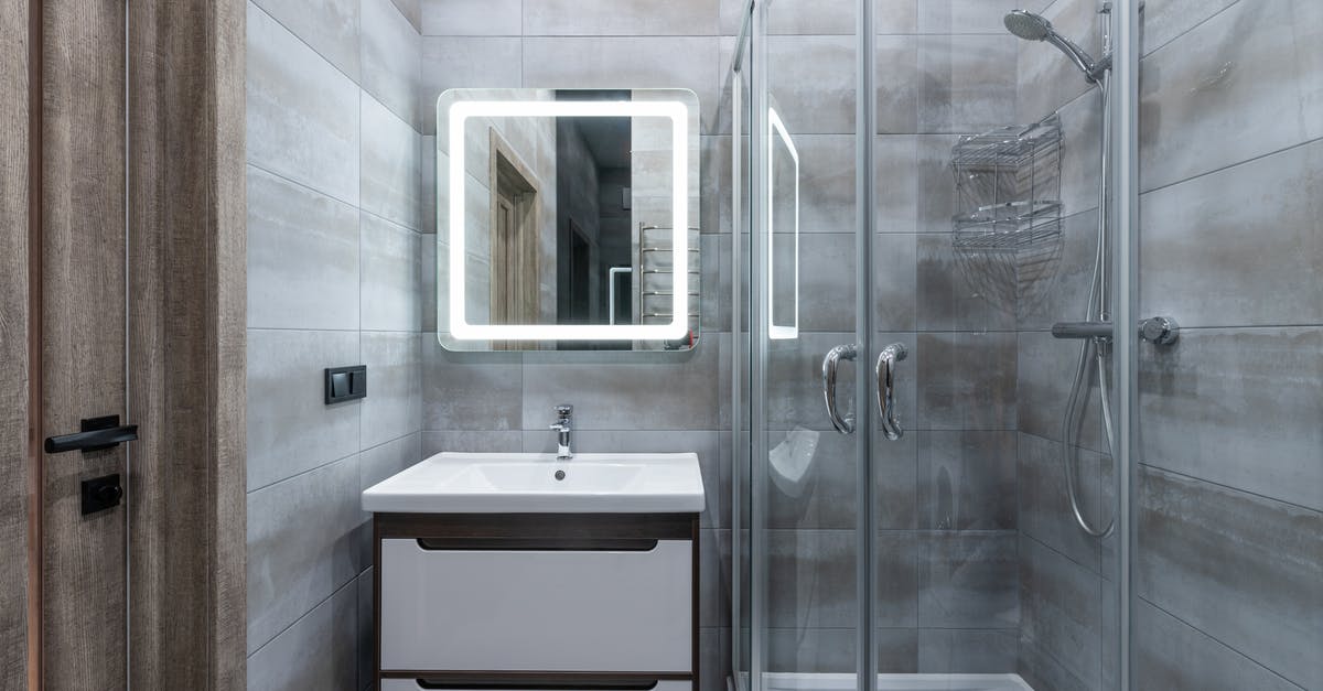 Why is the bathroom's light switch outside the room in some countries? - Contemporary washbasin under mirror against shower room with glass walls and tiles at home Why is the bathroom's light switch outside the room in some countries? - Contemporary washbasin under mirror against shower room with glass walls and tiles at home