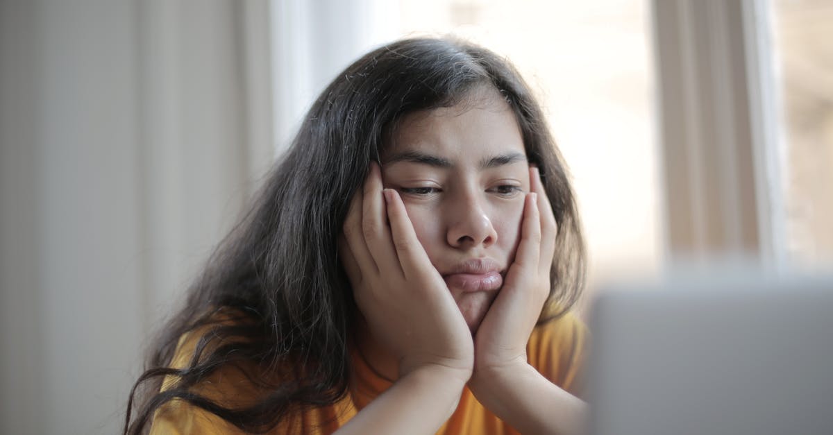 Why the price of a room at weekend is not mentioned? - Bored ethnic female in casual clothes sitting at table with netbook and watching sad movie while resting at home during weekend Why the price of a room at weekend is not mentioned? - Bored ethnic female in casual clothes sitting at table with netbook and watching sad movie while resting at home during weekend