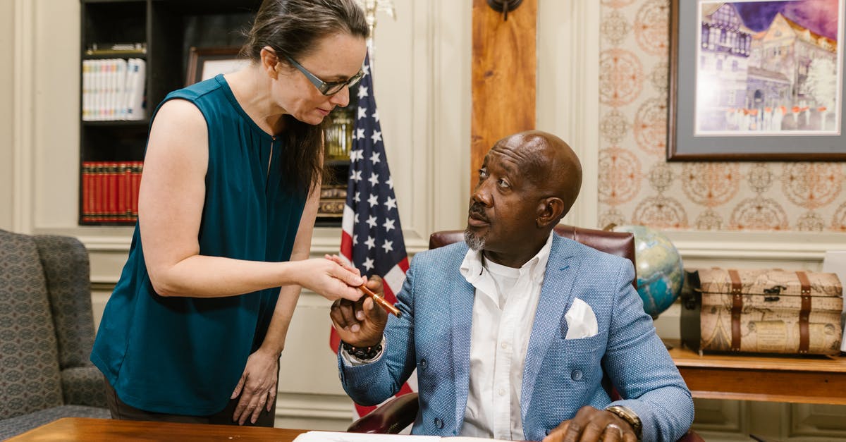 Why was my colleague refused a US B1 visa? - Man in Blue Dress Shirt Holding White Paper Why was my colleague refused a US B1 visa? - Man in Blue Dress Shirt Holding White Paper