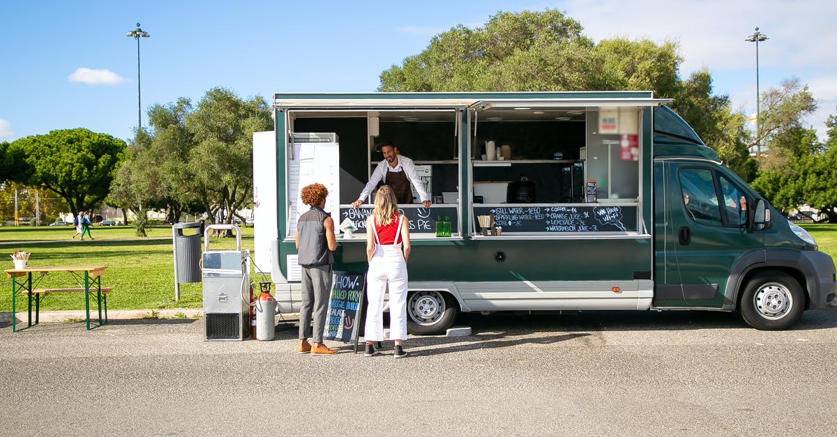 Why would I choose full service carrier instead of a low-cost one? - Couple standing near food truck and choosing food