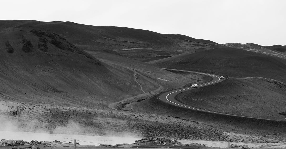 Wildcat trail when Valley Drive is closed - Black and white dry empty hillside with cars driving on road in desert land Wildcat trail when Valley Drive is closed - Black and white dry empty hillside with cars driving on road in desert land