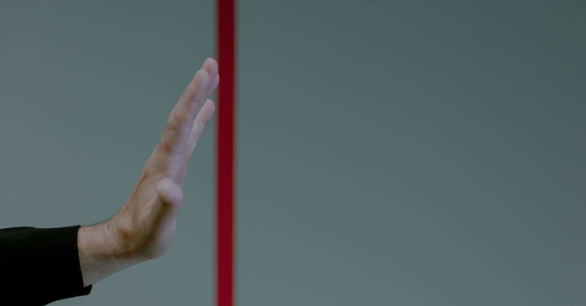 Will being detained at the UK border raise a stop indicator flag? [closed] - Studio shot of hand behind red line
