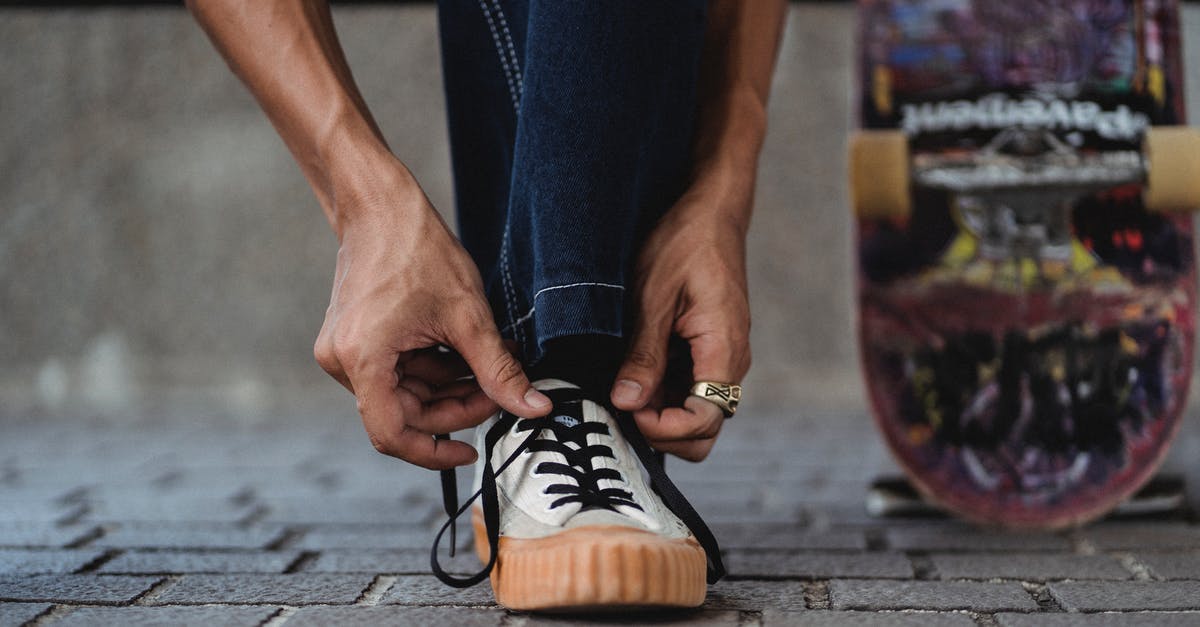 Will I be allowed to board a two-legged flight if I do not have the required visa for the second leg of the flight? [duplicate] - Crop unrecognizable man wearing jeans and ring on hand tying white sneakers on paved walkway with leaning colorful skateboard