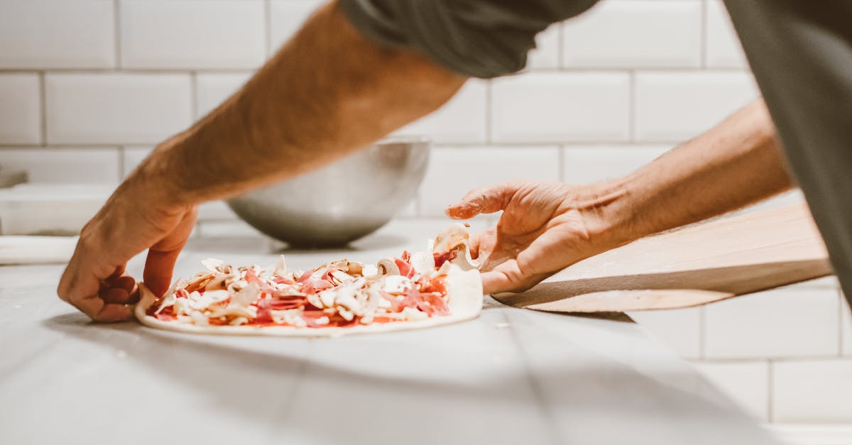 Will I be fined or arrested transferring through Finland with expired Schengen visa? [closed] - Person Transferring the Pizza Dough on a Wooden Paddle