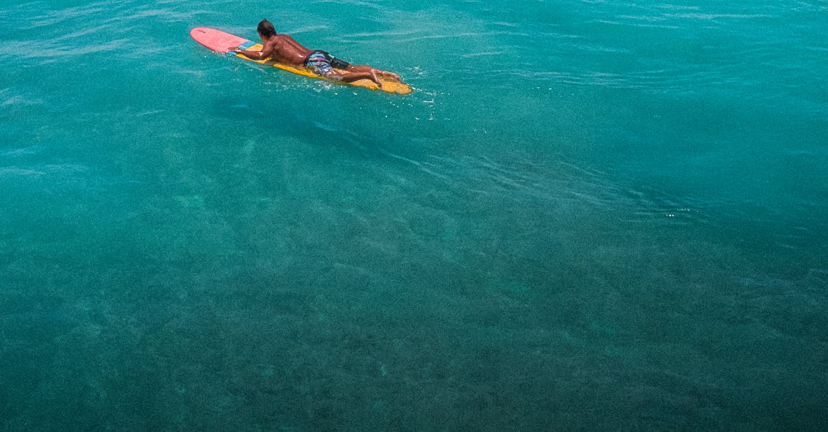 Will I clear customs in Honolulu or LAX? [duplicate] - Woman in Black and Yellow Bikini Lying on Orange Surfboard on Green Water