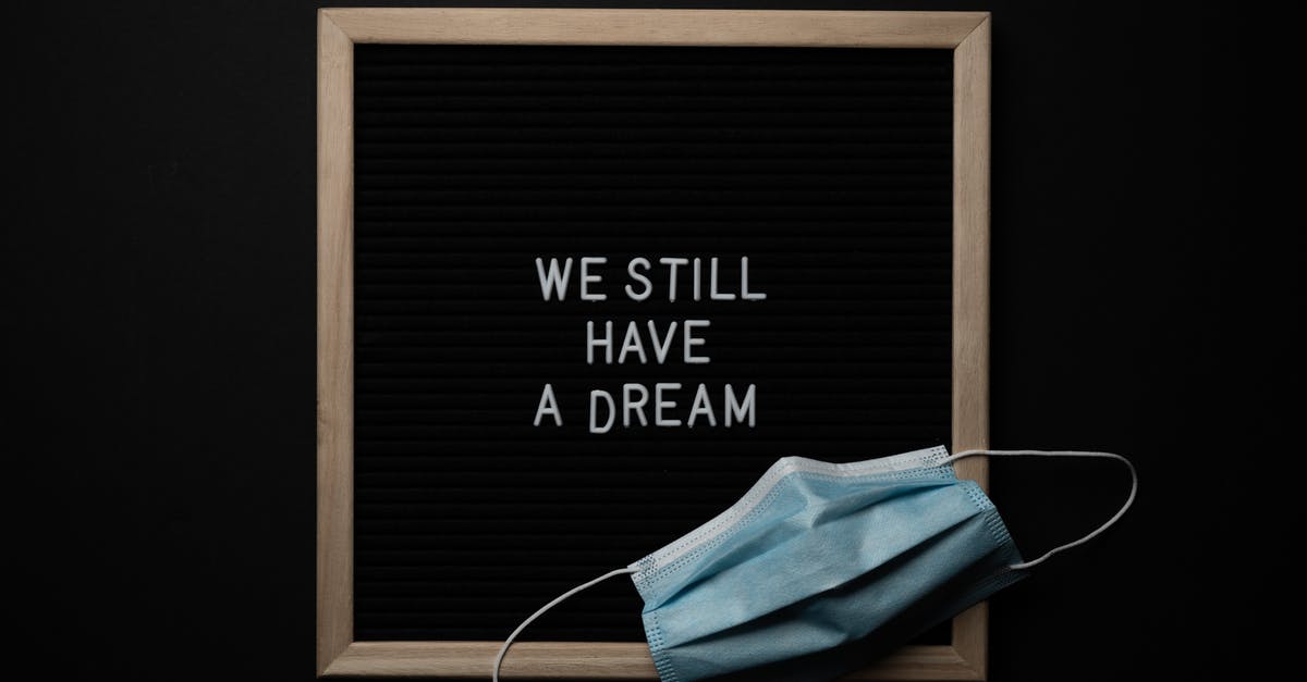 Will I have problems going to other countries after being refused entry to the UK? - Blackboard with wooden frame with white We Still Have a Dream inscription and medical mask placed on black background