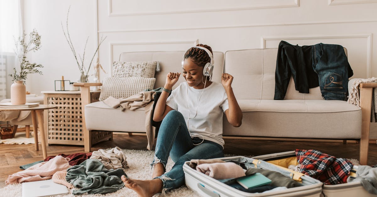 Will I have to get my luggage in Houston or it will be delivered to Tucson? - A Woman Listening on Her Headphones while Packing Will I have to get my luggage in Houston or it will be delivered to Tucson? - A Woman Listening on Her Headphones while Packing