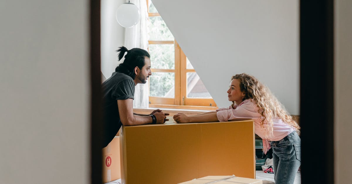 Will I have to pay duty for property that I will take back to country of purchase? [closed] - Side view from entrance of cheerful young ethnic bearded man with ponytail and woman with curly hair leaning on large cardboard package while arranging stuff in cozy attic bedroom