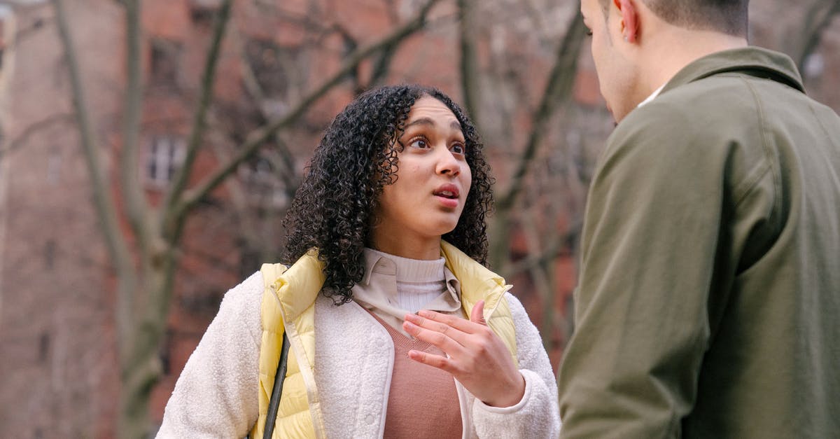 Will I have trouble at US Immigration if my appearance differes from my visa photo? - From below of ethnic female with short curly hair standing and arguing with boyfriend on street in daylight Will I have trouble at US Immigration if my appearance differes from my visa photo? - From below of ethnic female with short curly hair standing and arguing with boyfriend on street in daylight