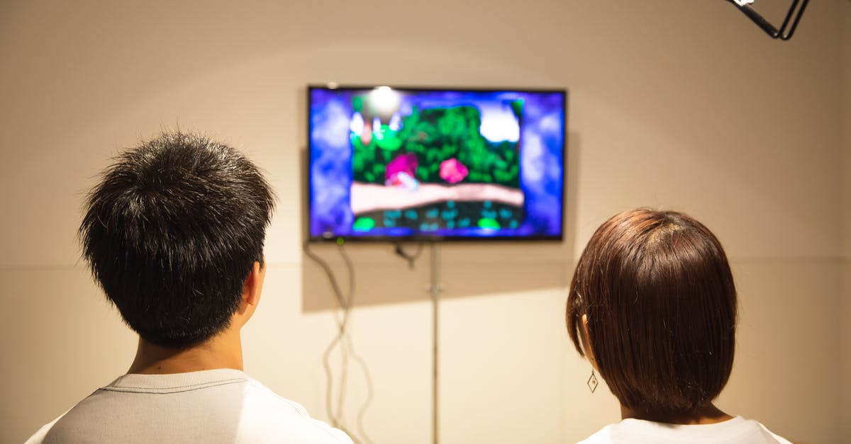 Will it harm my video game if I take it through the scanner? - Unrecognizable young couple playing video game at home