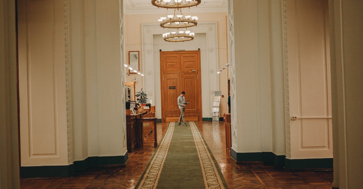 will my visa be refused due to my history of being refused entry to the uk? [closed] - Interior of old building with high decorated ceiling and massive wooden doorway in corridor