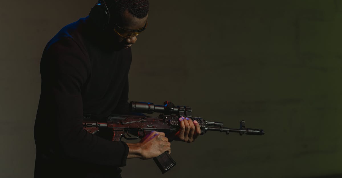Will the wearing of a silicone butt plug be detected by Security? [closed] - Man in Black Hoodie Holding Rifle