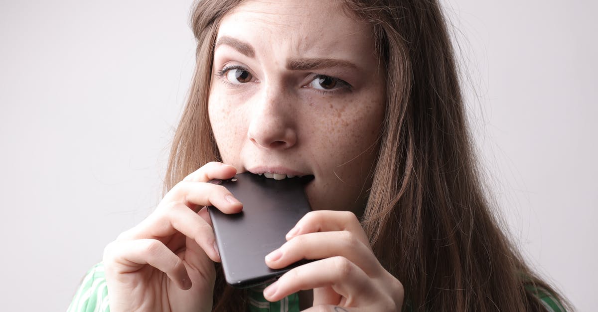 Will This Be A Problem With My UK Tier 5 Youth Mobility Visa? [duplicate] - Nervous young female in casual clothing standing with cellphone in mouth after unpleasant phone call on gray background in studio