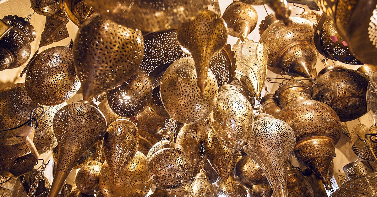 Withdrawing Euros from Moroccan ATMs? - From below of assorted ornamental Moroccan lamps with tiny holes on shiny surface in local market Withdrawing Euros from Moroccan ATMs? - From below of assorted ornamental Moroccan lamps with tiny holes on shiny surface in local market