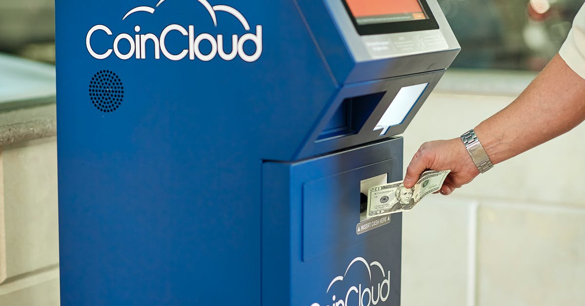 Withdrawing money in an ATM in Poland, is there a best network? - Hand Holding Dollar Bill up to ATM Withdrawing money in an ATM in Poland, is there a best network? - Hand Holding Dollar Bill up to ATM
