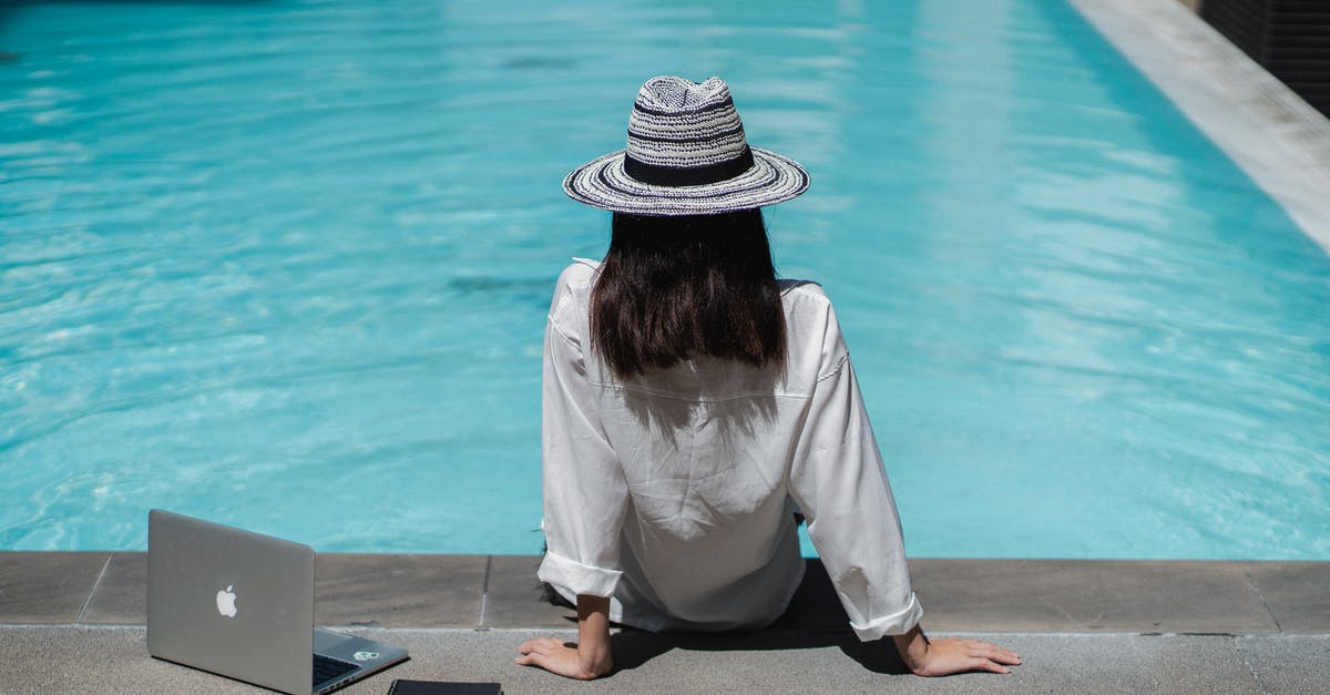 Working remotely on the French work and holiday visa? - Faceless female freelancer resting at poolside after work on laptop Working remotely on the French work and holiday visa? - Faceless female freelancer resting at poolside after work on laptop