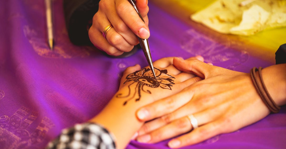 Would applying henna on my fingers change my fingerprints? - Close-Up Photo of Person Doing Mehndi Tattoo