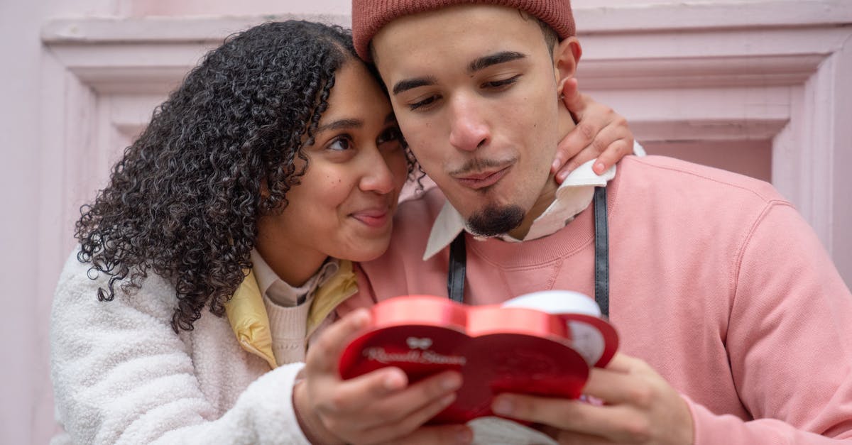 Would I be able to change the date on my Greyhound ticket and depart on the same day? [closed] - Joyful young ethnic couple embracing and eating yummy candies from heart shaped gift box during anniversary celebration