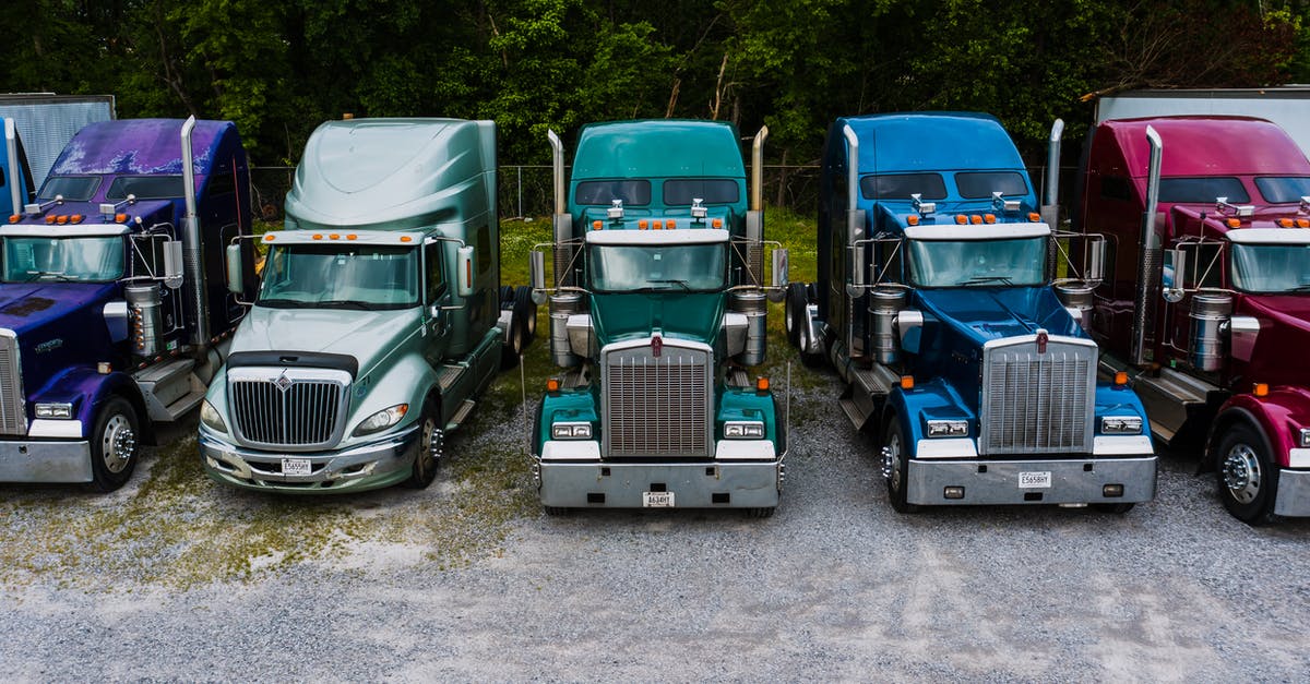 Would I be safe to drive a 23 year old truck for 7 hours / 450 miles? [closed] - Row of vintage classic trucks of different colors parked on roadside outside warehouse against lush trees