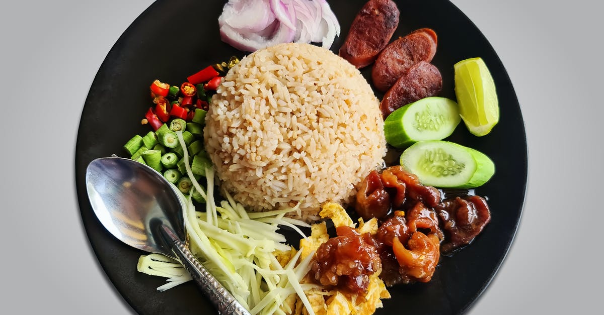 Would it be ok to eat rice using a spoon in front of Westerners? - Cooked Rice With Sliced Cucumber and Sliced Meat on Black Ceramic Plate Would it be ok to eat rice using a spoon in front of Westerners? - Cooked Rice With Sliced Cucumber and Sliced Meat on Black Ceramic Plate